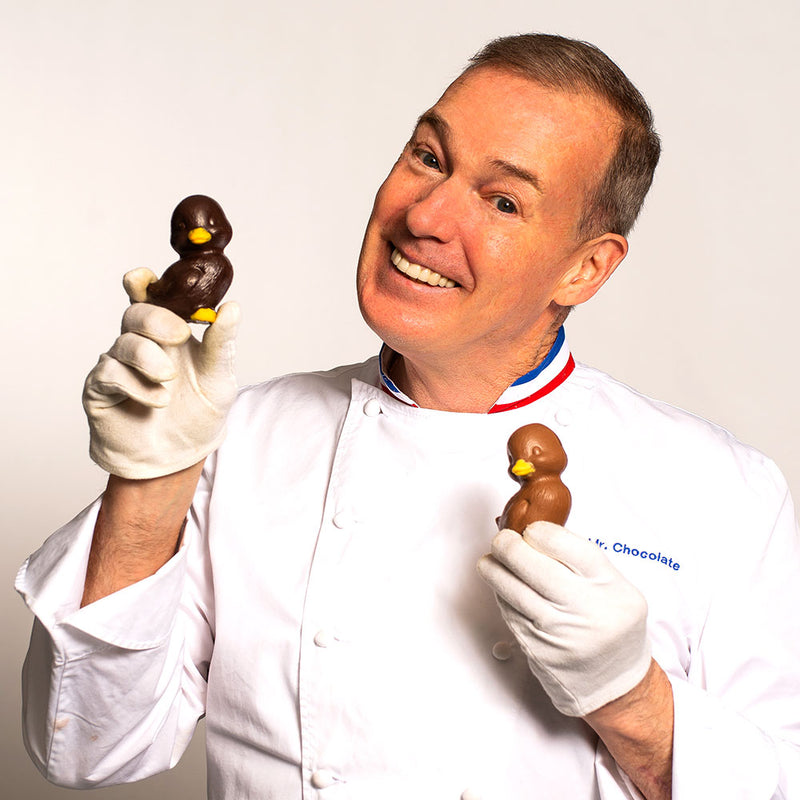 Chef Jacques Torres holding milk and dark chocolate Easter duckie
