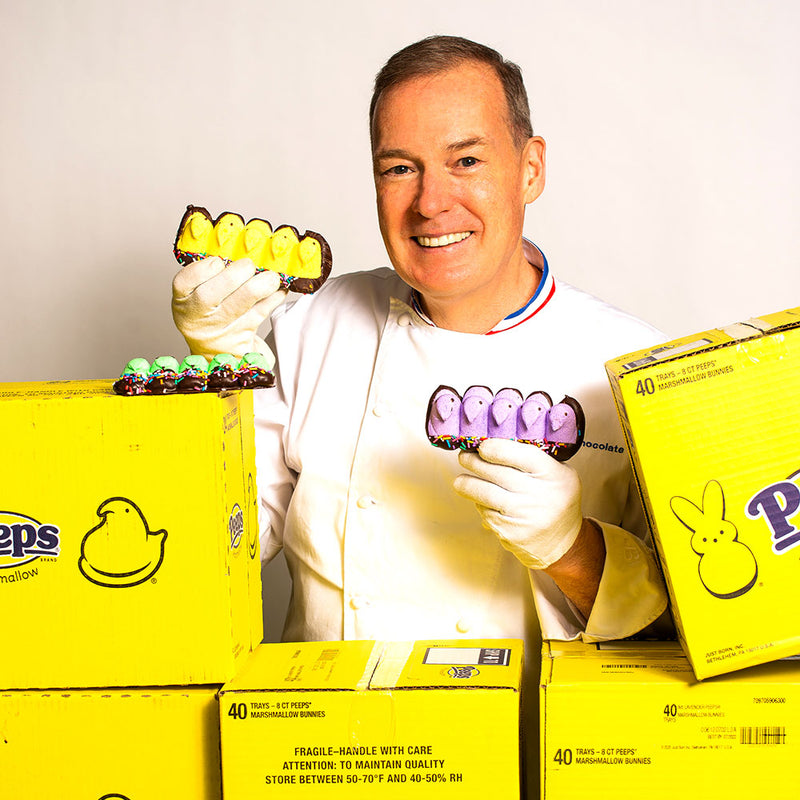Chef Jacques Torres holding chick Peeps covered  in milk and dark chocolate for Easter