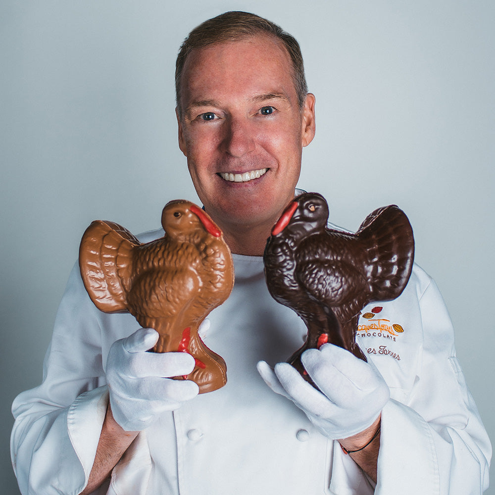 Jacques Torres holding medium dark and milk chocolate turkeys