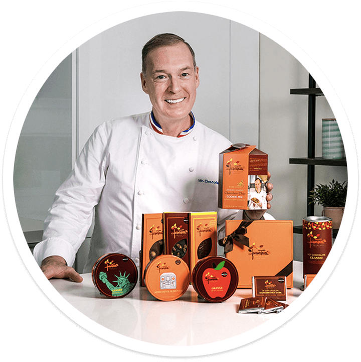 CHEF JACQUES TORRES with several of his products in a kitchen