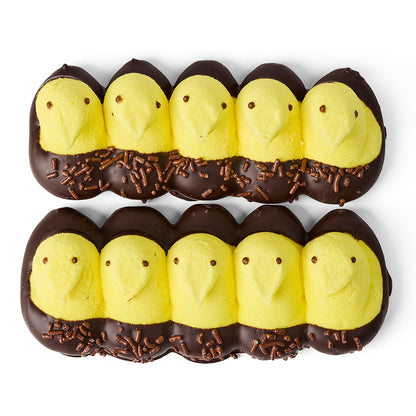 Chocolate-dipped yellow chick peeps with brown eyes and chocolate sprinkles on a white background