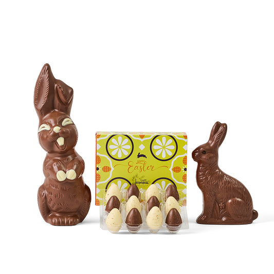 Chocolate Easter bunnies and eggs with a decorative Easter box on a white background