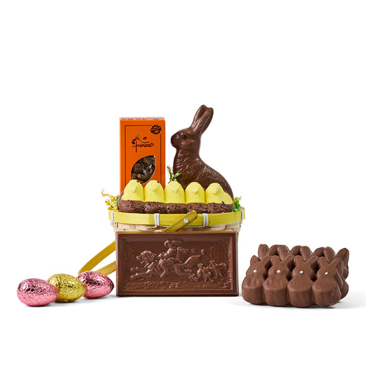 Chocolate Easter basket with bunny, eggs, and other treats on a white background
