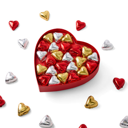 Heart-shaped box of assorted foil-wrapped chocolates on a white background